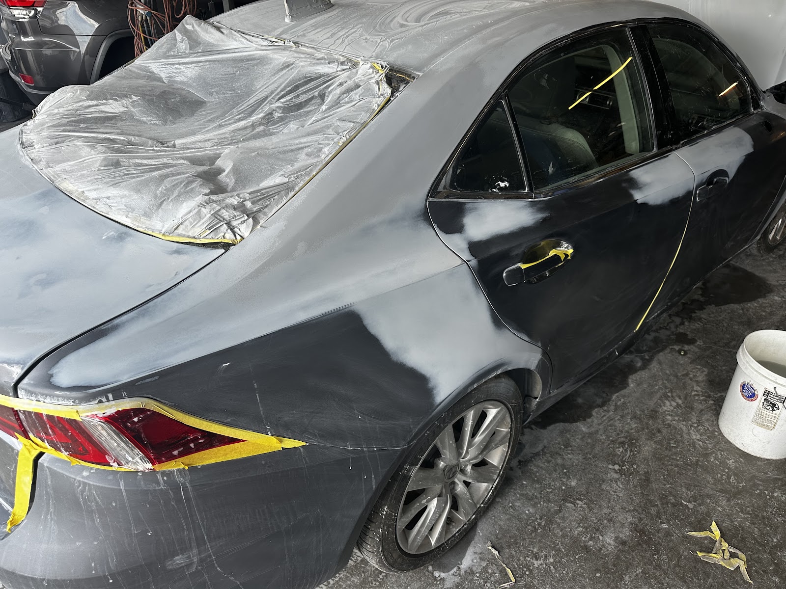 Lexus IS sedan in primer with masking during bodywork at 8SRT Collision and Paint